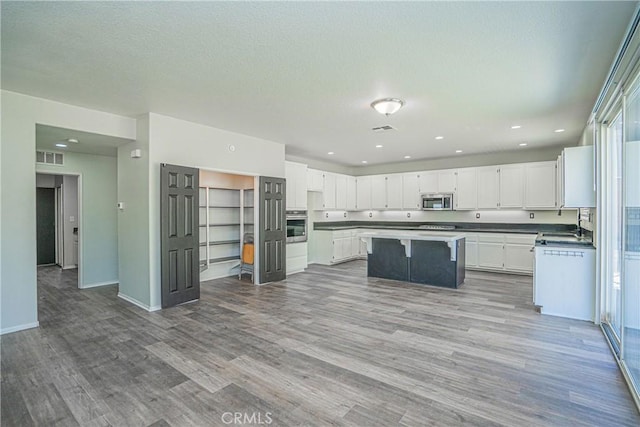 11935 Silver, Jurupa Valley, CA 91752 - kitchen featuring appliances with stainless steel finishes, wood finished floors, a center island, white cabinetry, and recessed lighting