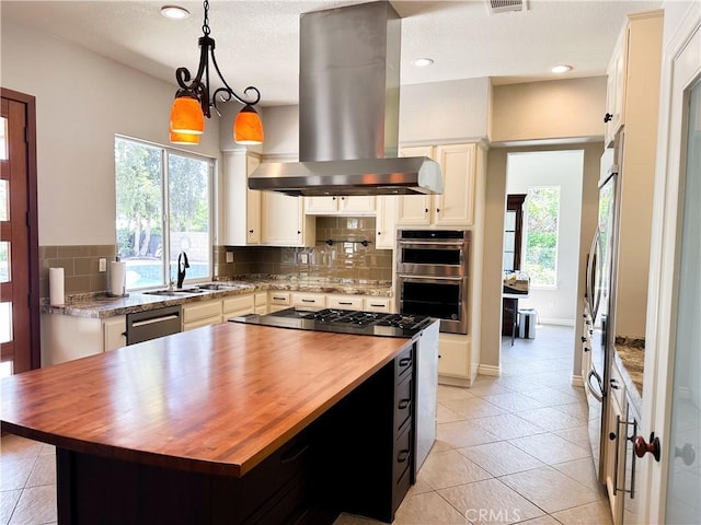 1073 Peter Christian Cir, Corona, CA 92881 - kitchen featuring butcher block countertops, island exhaust hood, healthy amount of natural light, appliances with stainless steel finishes, and recessed lighting