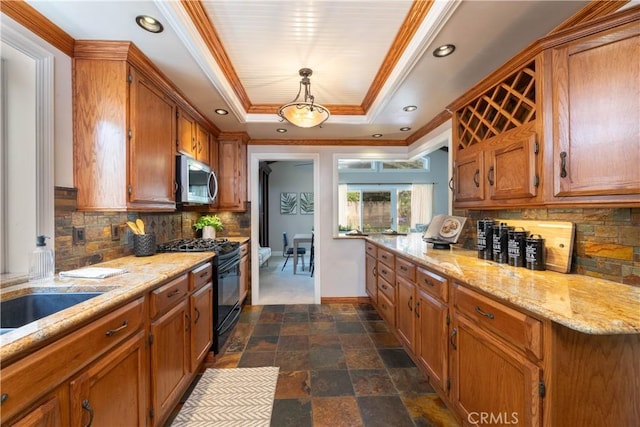 1915 Volk Ave, Long Beach, CA 90815 - kitchen with black gas range, a tray ceiling, stainless steel microwave, brown cabinets, and ornamental molding