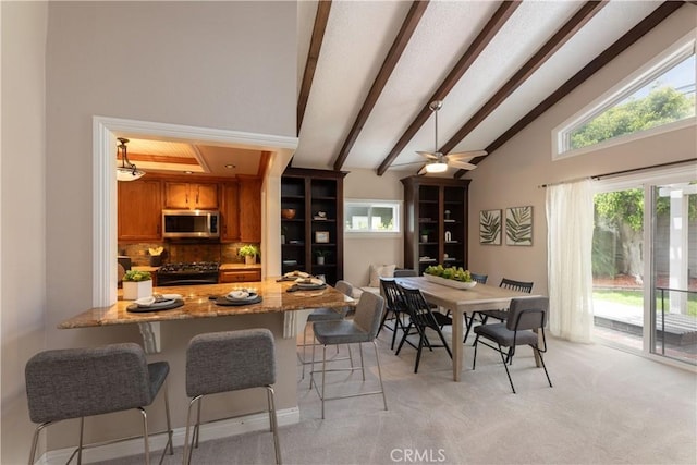 1915 Volk Ave, Long Beach, CA 90815 - kitchen with stainless steel microwave, black gas range, brown cabinetry, light carpet, and light stone countertops