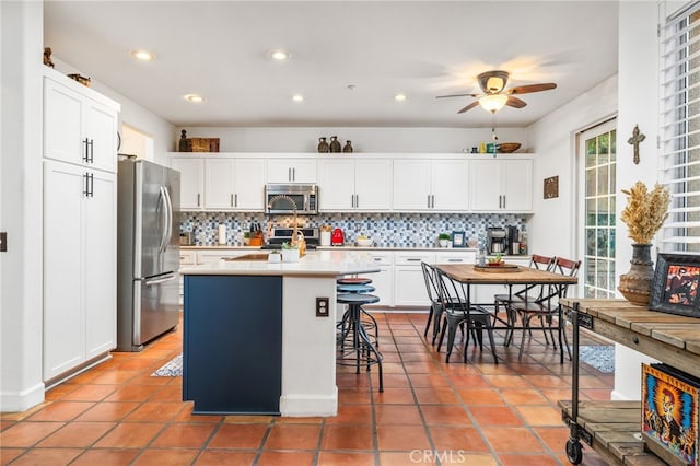 30050 Cabo Del Oeste, Highland, CA 92346 - kitchen featuring stainless steel appliances, tasteful backsplash, ceiling fan, light countertops, and white cabinetry
