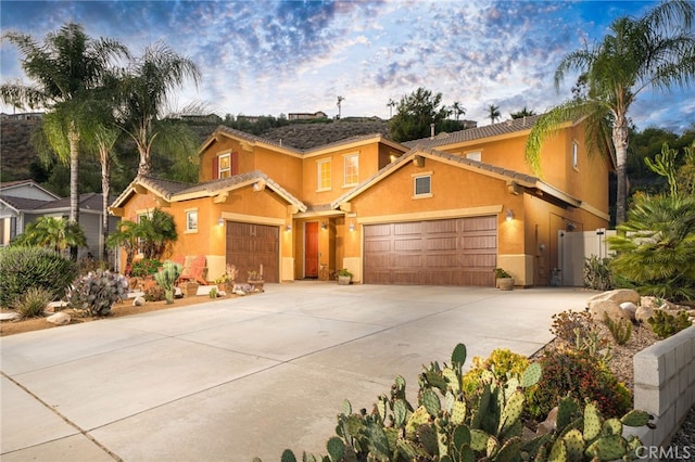30050 Cabo Del Oeste, Highland, CA 92346 - view of front of home with stucco siding, an attached garage, concrete driveway, and a gate