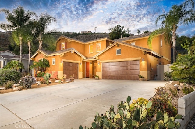 30050 Cabo Del Oeste, Highland, CA 92346 - view of front of property with stucco siding, concrete driveway, a garage, and a gate