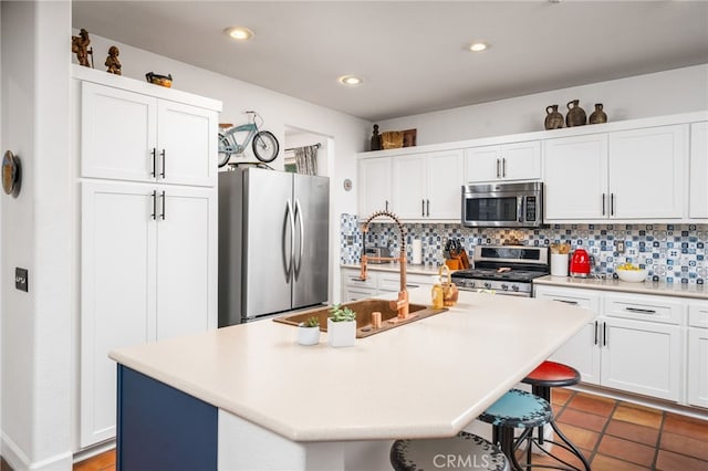 30050 Cabo Del Oeste, Highland, CA 92346 - kitchen with stainless steel appliances, a kitchen bar, tasteful backsplash, white cabinets, and recessed lighting