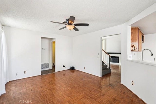 1497 Ruby Dr, Perris, CA 92571 - spare room featuring a ceiling fan, stairway, and a textured ceiling