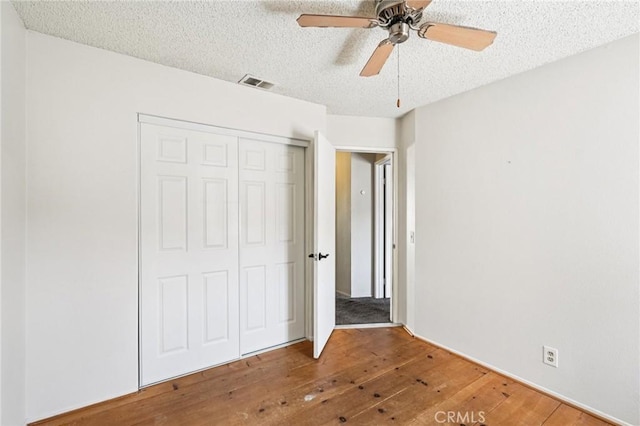 1497 Ruby Dr, Perris, CA 92571 - unfurnished bedroom with wood-type flooring, a closet, a textured ceiling, and a ceiling fan
