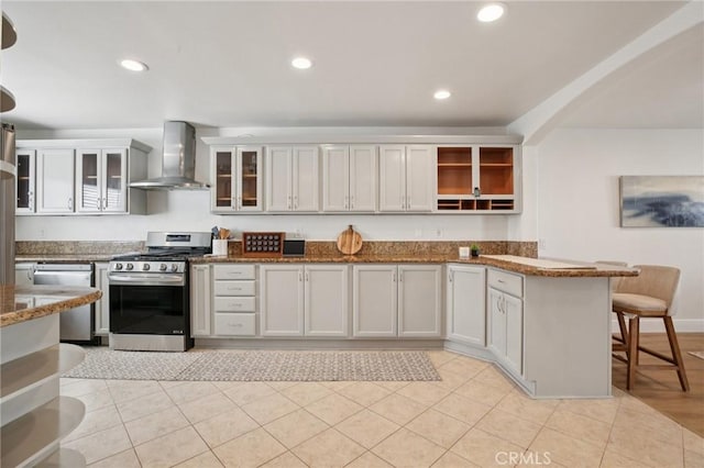 22832 Larkin St, Lake Forest, CA 92630 - kitchen featuring wall chimney range hood, stainless steel appliances, a peninsula, open shelves, and dark stone counters