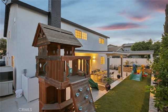 22832 Larkin St, Lake Forest, CA 92630 - rear view of property featuring a chimney, stucco siding, a wooden deck, and a playground