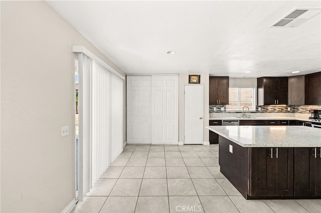 25969 Magnifica Ct, Moreno Valley, CA 92551 - kitchen with dark brown cabinets, tasteful backsplash, light tile patterned flooring, and a kitchen island