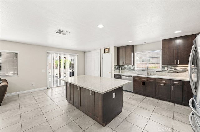 25969 Magnifica Ct, Moreno Valley, CA 92551 - kitchen featuring stainless steel appliances, tasteful backsplash, healthy amount of natural light, light tile patterned flooring, and recessed lighting