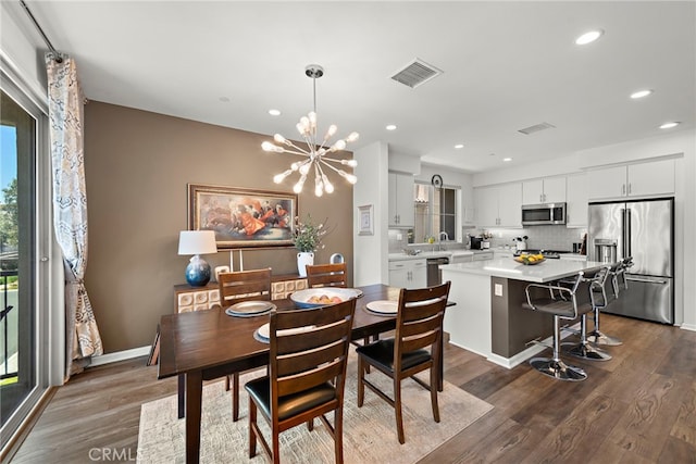 527 S Motif St, Anaheim, CA 92805 - dining room featuring plenty of natural light, dark wood-style flooring, a chandelier, and recessed lighting
