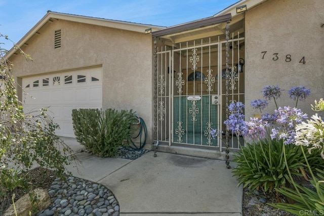 7384 Ballinger, San Diego, CA 92119 - view of exterior entry with stucco siding and a garage