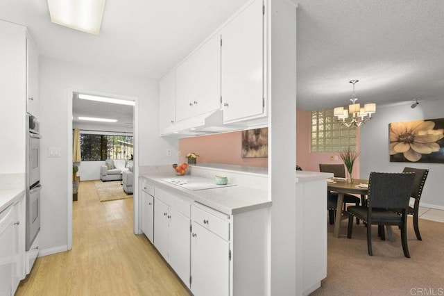 7384 Ballinger, San Diego, CA 92119 - kitchen with a chandelier, light countertops, white cabinetry, and light wood-style flooring