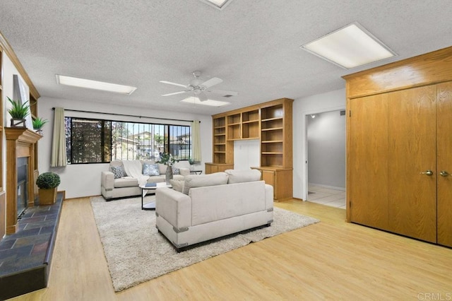 7384 Ballinger, San Diego, CA 92119 - living area with a textured ceiling, wood finished floors, a tile fireplace, and a ceiling fan