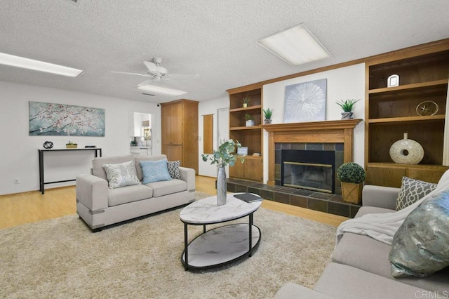 7384 Ballinger, San Diego, CA 92119 - living area with wood finished floors, a tiled fireplace, a textured ceiling, and ceiling fan