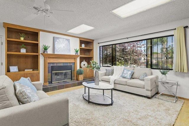 7384 Ballinger, San Diego, CA 92119 - living area with wood finished floors, a tiled fireplace, a ceiling fan, and a textured ceiling