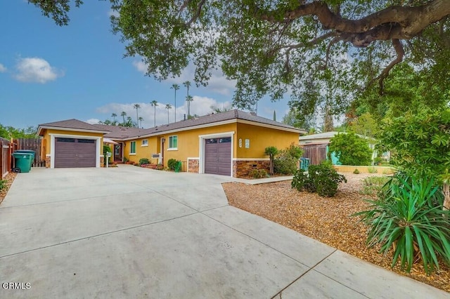  - single story home with stone siding, an attached garage, driveway, and stucco siding