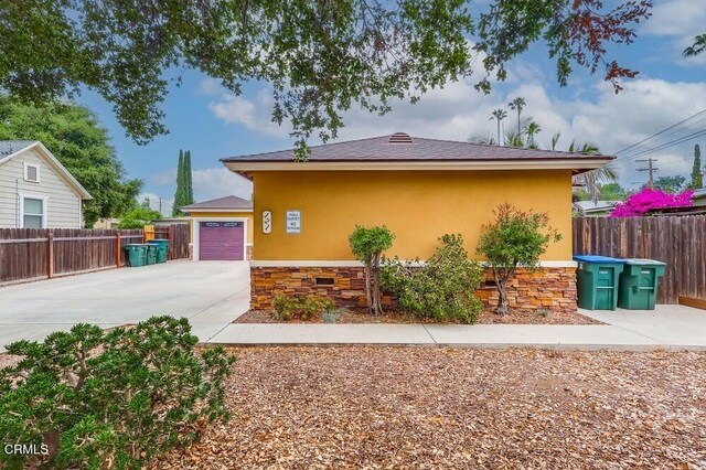  - view of property exterior with driveway and stone siding