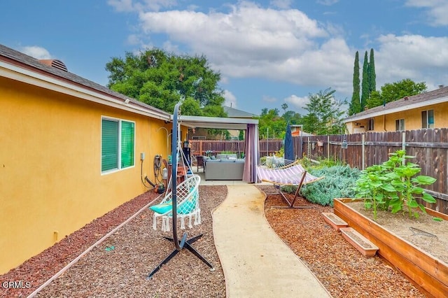  - fenced backyard featuring a garden, a patio area, and an outdoor living space