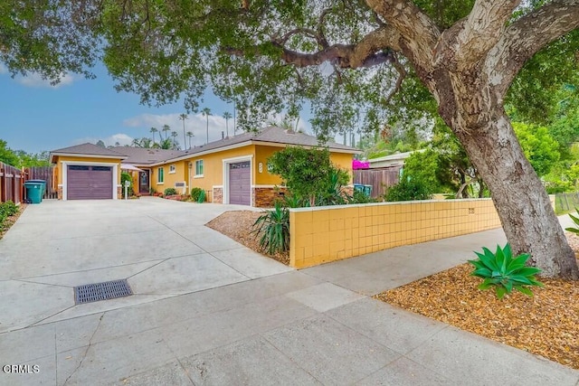 - ranch-style house featuring driveway, an attached garage, and stucco siding