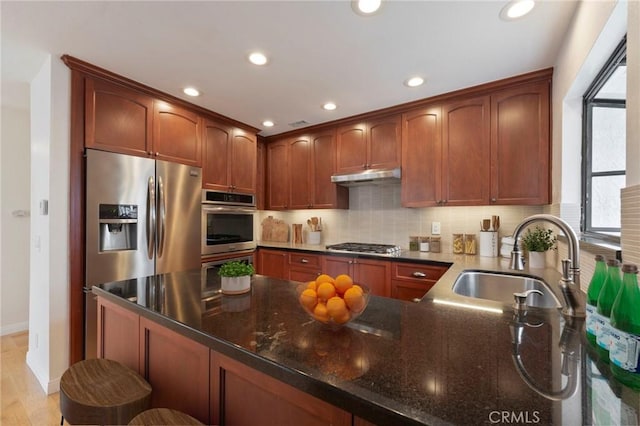 9765 Alburtis Ave Unit 131, Santa Fe Springs, CA 90670 - kitchen with under cabinet range hood, appliances with stainless steel finishes, healthy amount of natural light, recessed lighting, and dark stone countertops