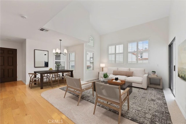 9765 Alburtis Ave Unit 131, Santa Fe Springs, CA 90670 - living room with a chandelier, light wood-style flooring, and a high ceiling