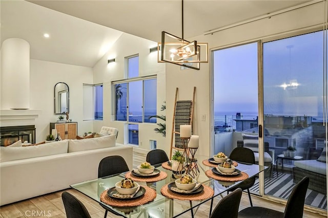 4216 Highland Ave Unit B, Manhattan Beach, CA 90266 - dining room with light wood-style floors, a chandelier, vaulted ceiling, and a glass covered fireplace