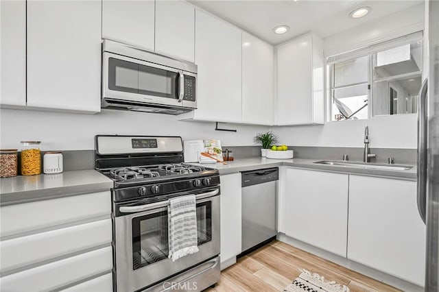 4216 Highland Ave Unit B, Manhattan Beach, CA 90266 - kitchen with stainless steel appliances, white cabinets, light countertops, light wood finished floors, and recessed lighting