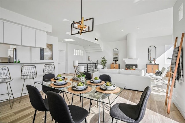 4216 Highland Ave Unit B, Manhattan Beach, CA 90266 - dining room featuring a chandelier, light wood finished floors, and a glass covered fireplace