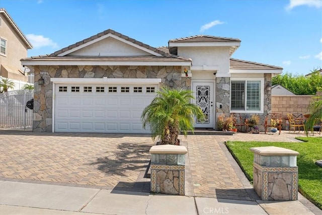 253 Kieswetter St, Colton, CA 92324 - view of front of property featuring stone siding, a tile roof, driveway, a garage, and stucco siding