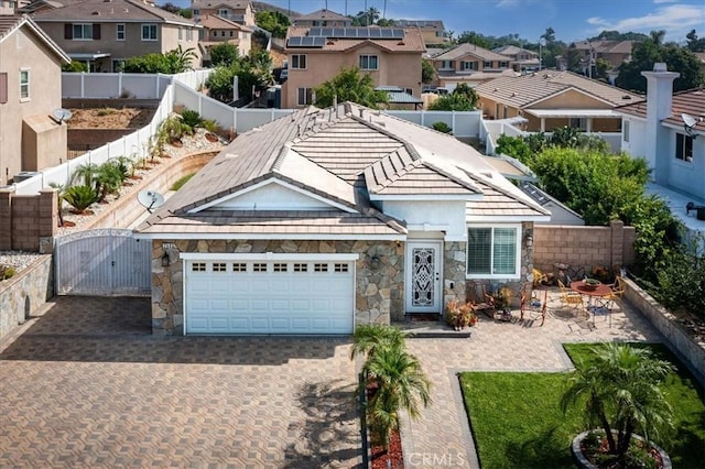 253 Kieswetter St, Colton, CA 92324 - view of front of house with a residential view, stone siding, a fenced backyard, and decorative driveway
