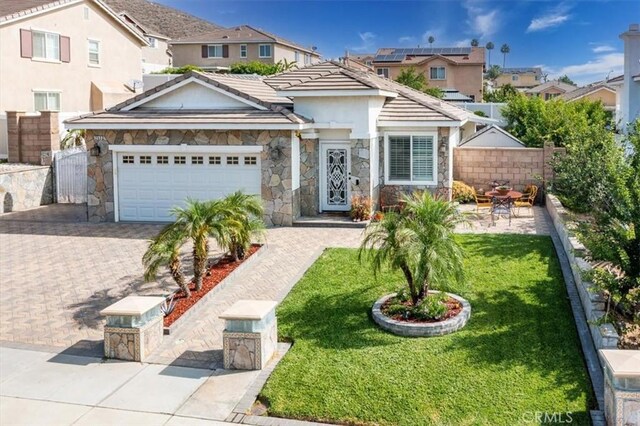 253 Kieswetter St, Colton, CA 92324 - view of front of home with stone siding, an attached garage, stucco siding, a residential view, and driveway