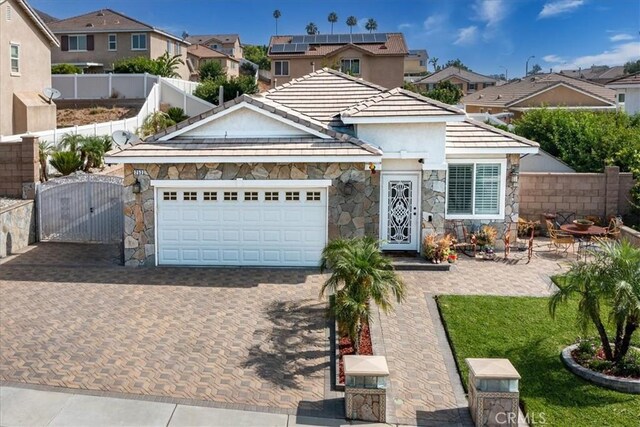 253 Kieswetter St, Colton, CA 92324 - view of front facade with stone siding, a gate, a residential view, and driveway