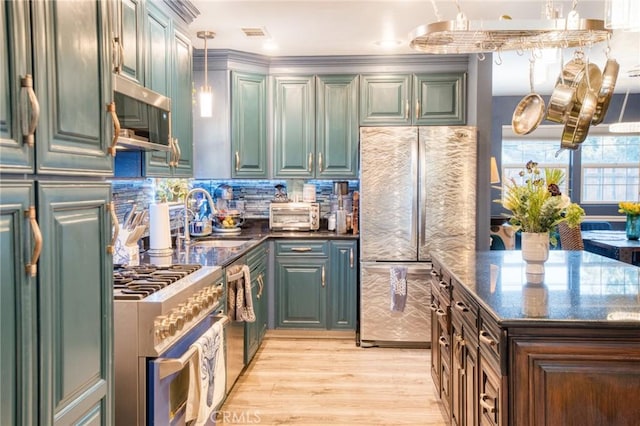 7695 Valle Ave, Atascadero, CA 93422 - kitchen with premium appliances, light wood-style floors, hanging light fixtures, backsplash, and dark stone counters