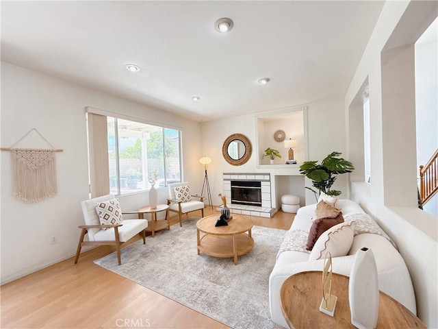13128 Pintail Ct, Chino, CA 91710 - living room with light wood-style floors, a tiled fireplace, recessed lighting, and stairs