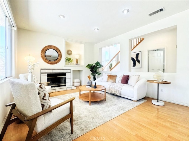 13128 Pintail Ct, Chino, CA 91710 - living room with wood finished floors, a fireplace, stairs, and recessed lighting