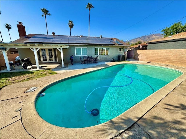 3425 Clifton Ave, Highland, CA 92346 - back of house featuring french doors, solar panels, a patio area, and a fenced backyard