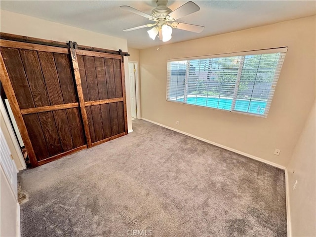 3425 Clifton Ave, Highland, CA 92346 - unfurnished bedroom featuring carpet, a ceiling fan, and a barn door