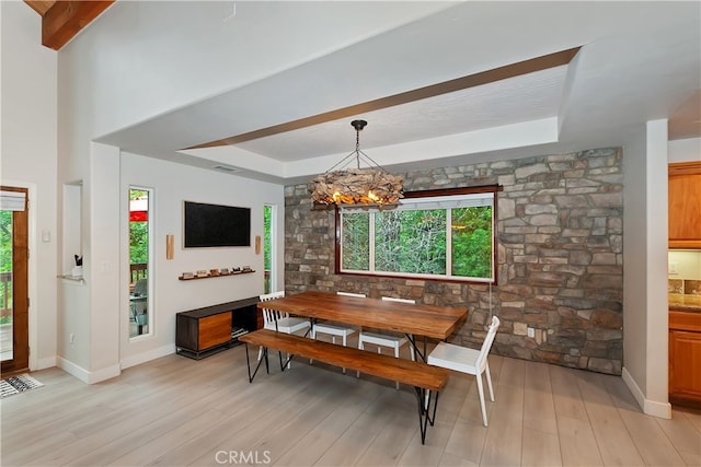 24586 Horst Dr, Crestline, CA 92325 - dining area featuring a raised ceiling, plenty of natural light, a chandelier, and light wood-style flooring