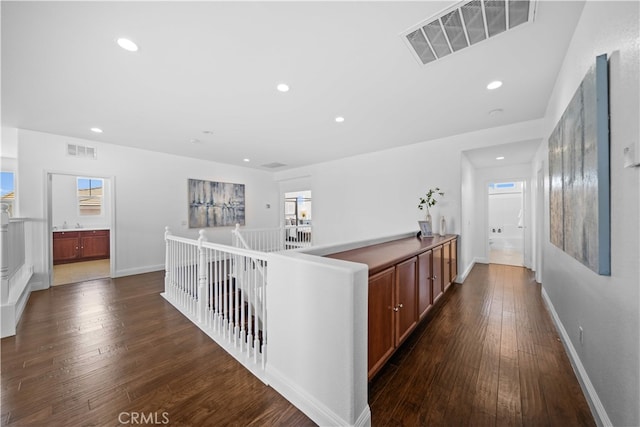 7265 Excelsior Dr, Eastvale, CA 92880 - hall with dark wood finished floors, recessed lighting, plenty of natural light, and an upstairs landing