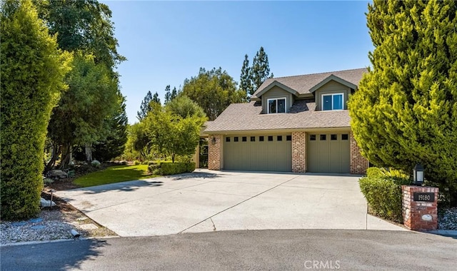 19180 Palm Vis, Yorba Linda, CA 92886 - view of front facade featuring brick siding, driveway, a garage, and a shingled roof