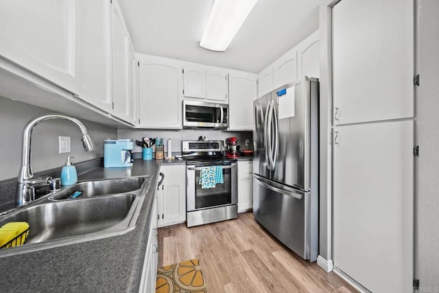 218 Holiday Way, Oceanside, CA 92057 - kitchen featuring stainless steel appliances, dark countertops, light wood-type flooring, and white cabinets