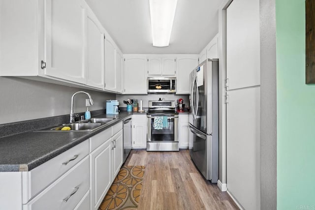 218 Holiday Way, Oceanside, CA 92057 - kitchen featuring appliances with stainless steel finishes, white cabinetry, wood finished floors, and dark countertops