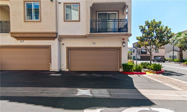 168 Royal Way, Upland, CA 91786 - view of property featuring stucco siding, a garage, asphalt driveway, and a balcony