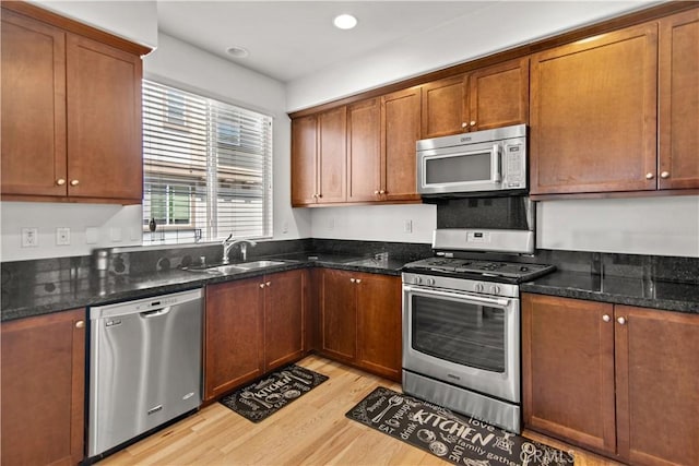 168 Royal Way, Upland, CA 91786 - kitchen featuring appliances with stainless steel finishes, light wood-type flooring, dark stone counters, recessed lighting, and brown cabinetry