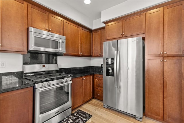 168 Royal Way, Upland, CA 91786 - kitchen featuring stainless steel appliances, light wood finished floors, dark stone countertops, and brown cabinetry