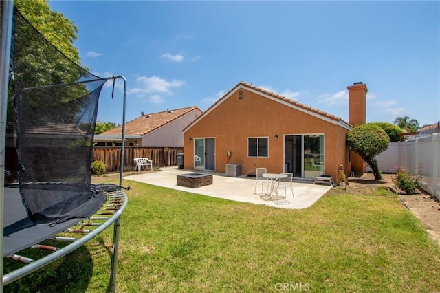 31858 Corte Priego, Temecula, CA 92592 - rear view of house with a trampoline, a fire pit, stucco siding, a patio, and a chimney