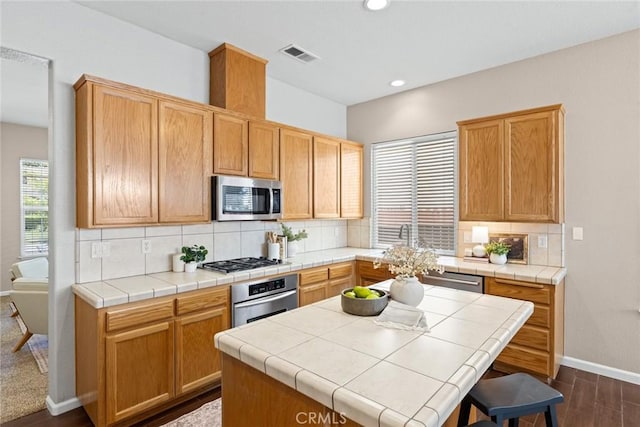 1619 Harvest Glen Dr, Chico, CA 95928 - kitchen featuring appliances with stainless steel finishes, decorative backsplash, dark wood-type flooring, recessed lighting, and tile countertops