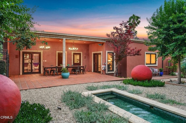 1897 Braemar Rd, Pasadena, CA 91103 - back of property at dusk with a patio area, stucco siding, and an in-ground hot tub