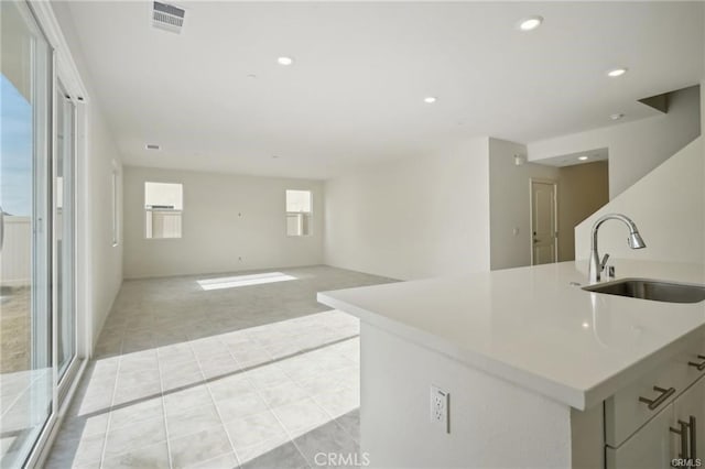 34261 Summer Ln, Yucaipa, CA 92399 - kitchen featuring light tile patterned floors, recessed lighting, light countertops, light carpet, and a kitchen island with sink